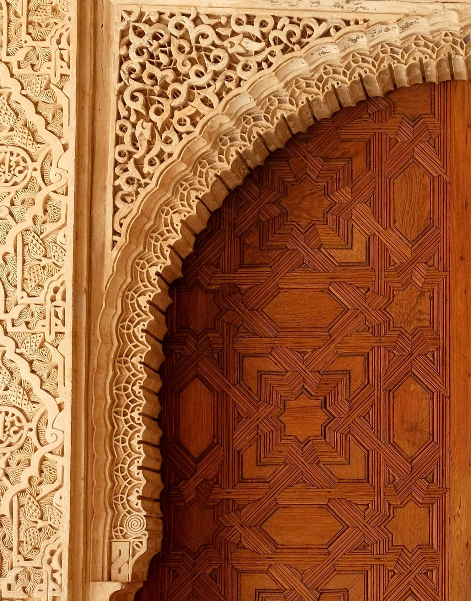 Close-up of a wooden door with intricate geometric carvings and a detailed wooden frame.