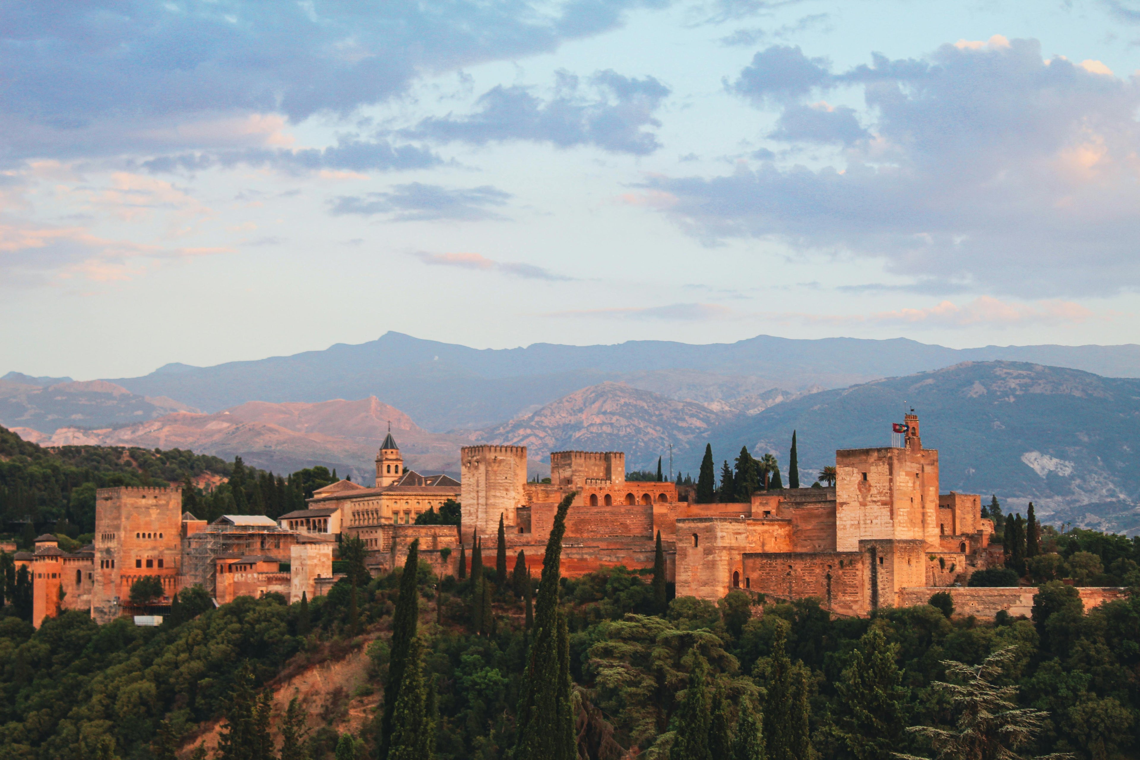 The historic Islamic Alhambra fortress and palace in Grenada with mountains in the background