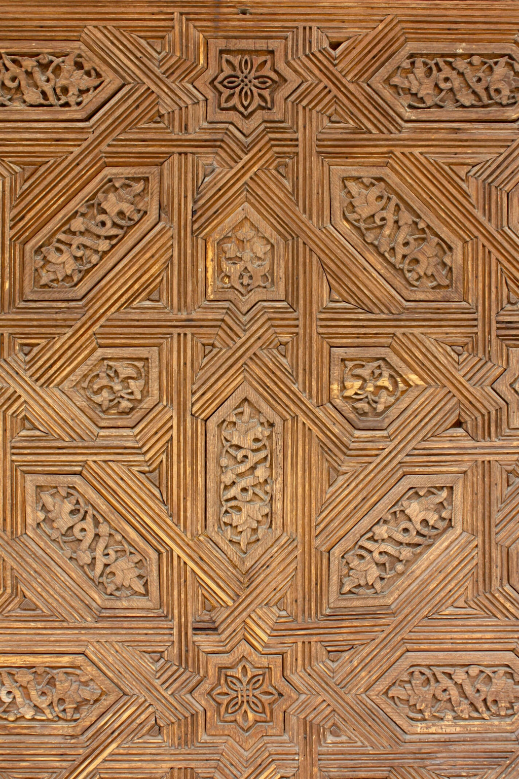 Close-up of a wooden Islamic Art panel with intricate geometric carvings like that of Islamic Decor