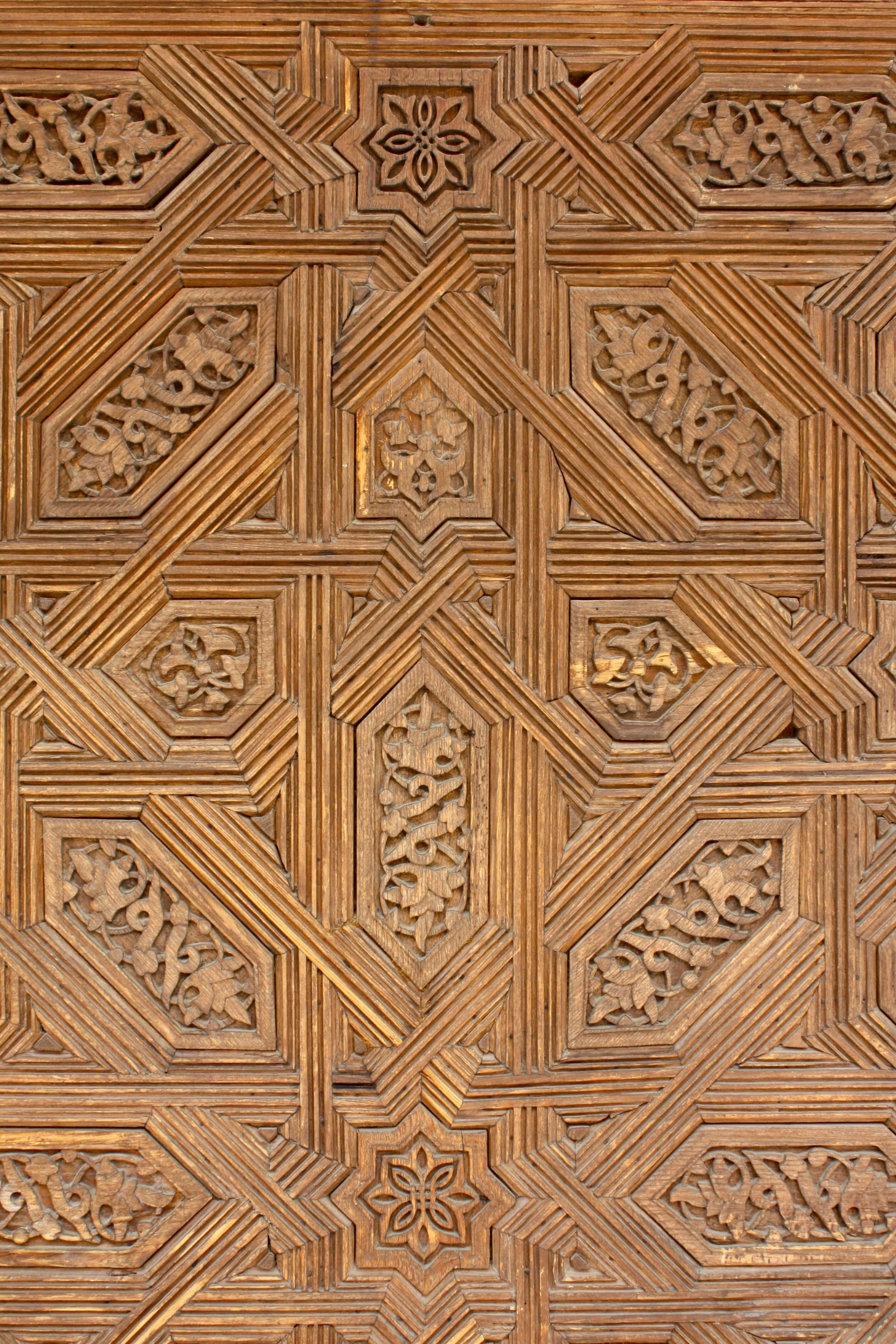 Close-up of a wooden Islamic Art panel with intricate geometric carvings like that of Islamic Decor